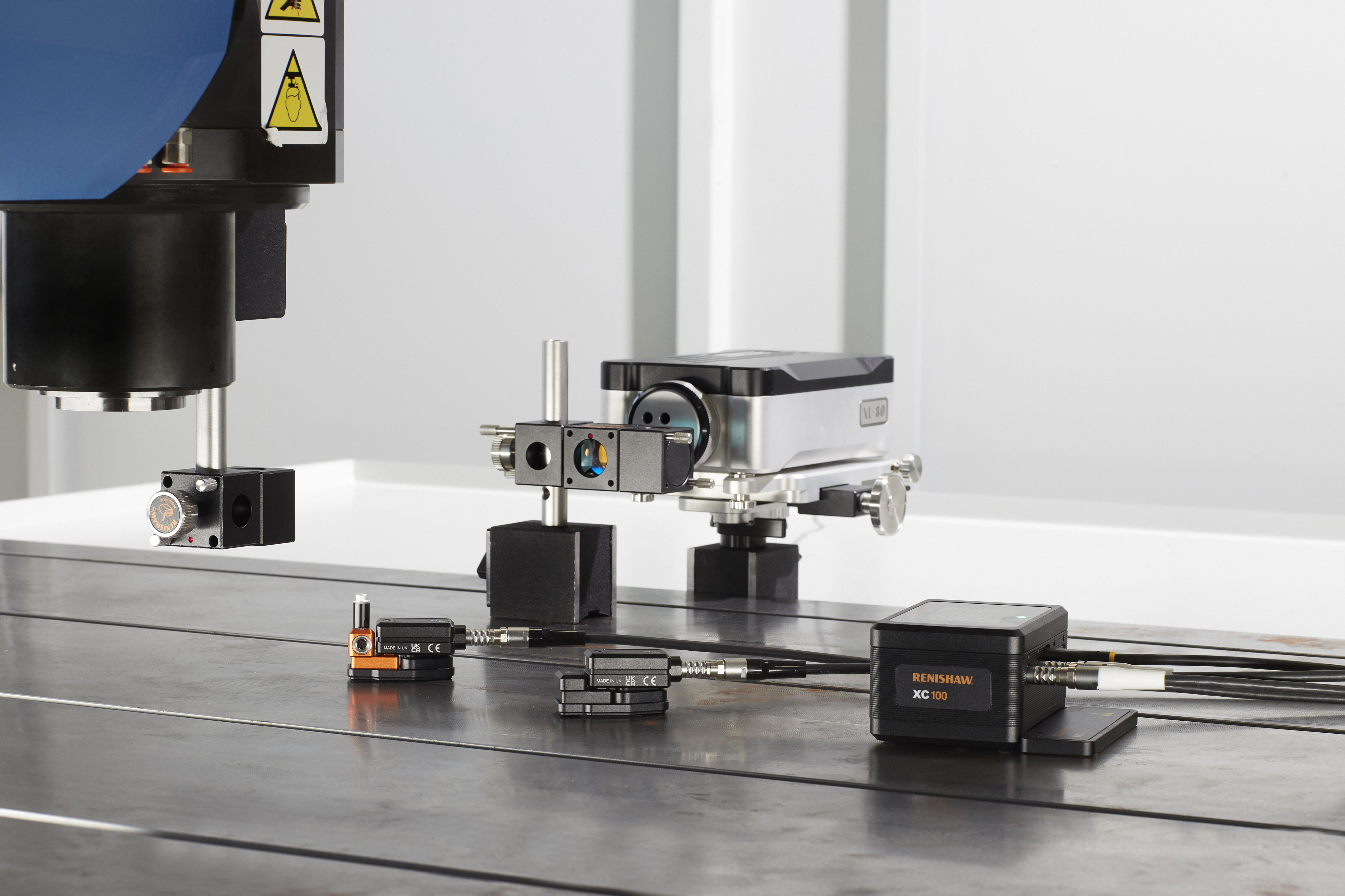 An XL-80 interferometer is set up on a machine bed with optics in place. The XC100 hub and sensors are in place.