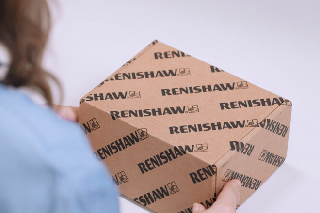 Renishaw cardboard product box being held by the hands of a Renishaw employee