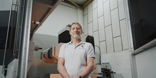 Effective CNC公司的Gary Pearson站在数控机床前